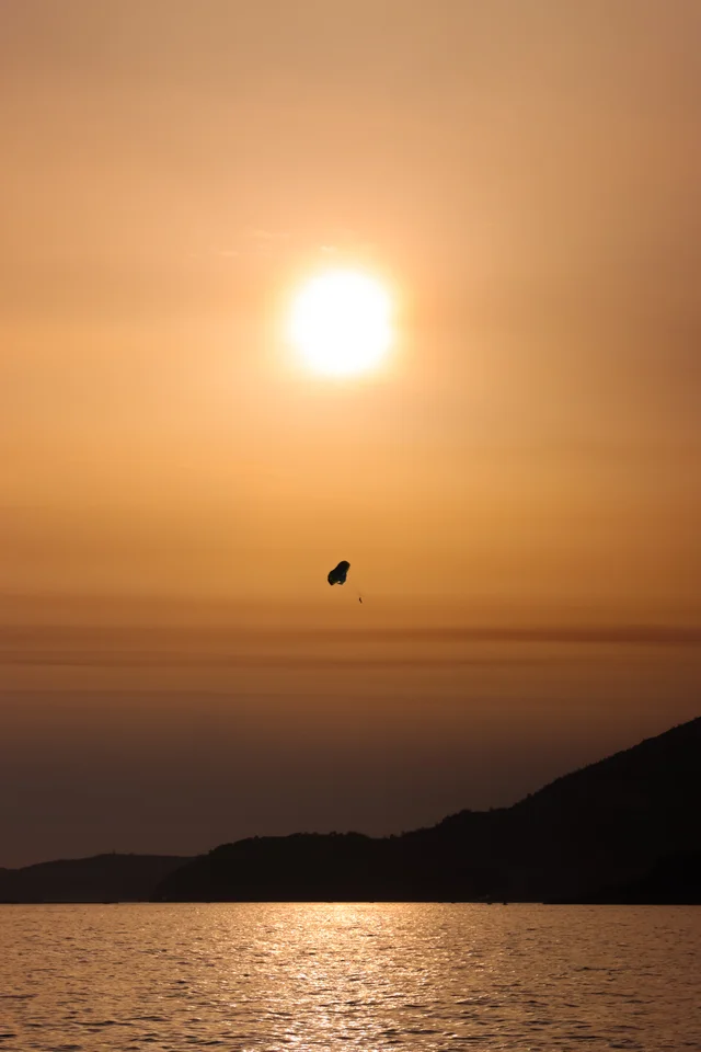 Parasailing over the sea at golden sunset