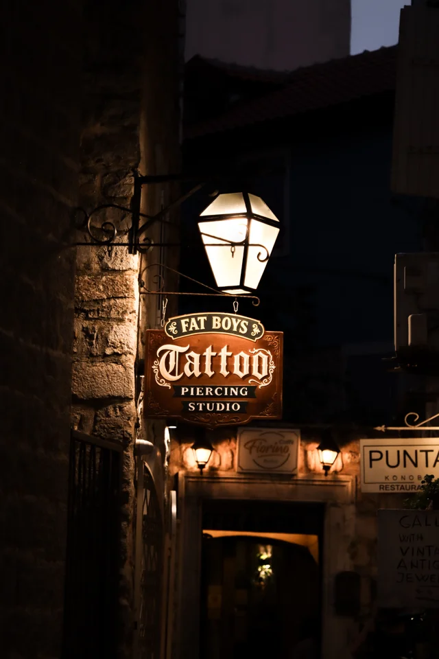 Warm lantern above a tattoo studio in an old town street